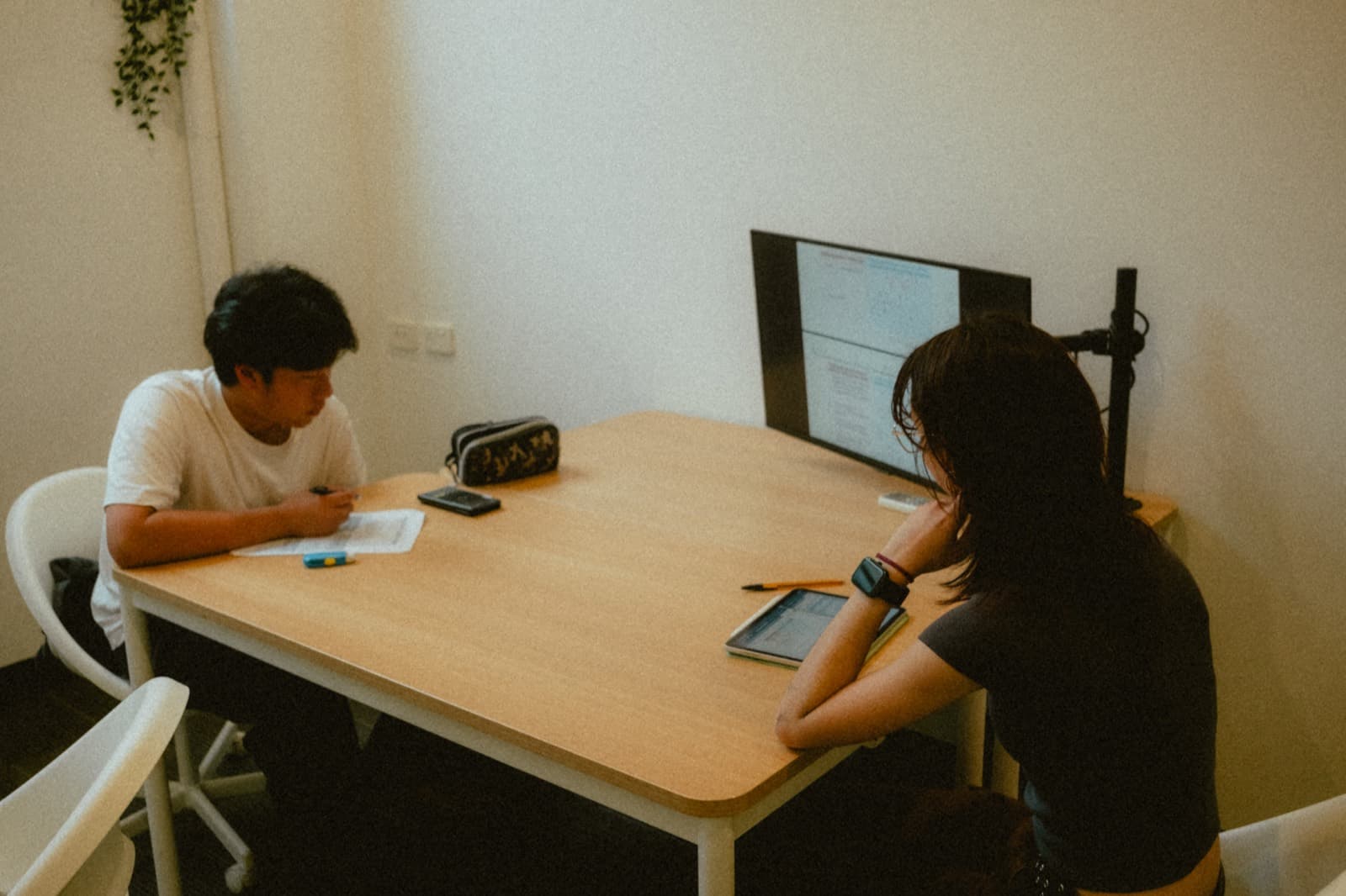A tutor and student working one to one at a desk